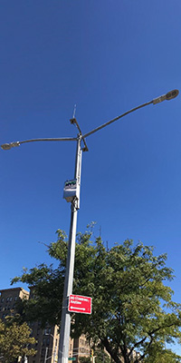 A streetlight pole with an NYC DEP box attached near the top of the pole.