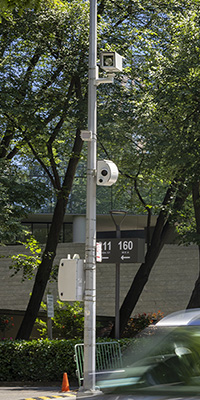 A streetlight pole in NYC with speed camera equipment attached to it. 
